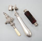 A silver mounted rattle, a white metal mounted double ended ruby glass cent bottle and a silver
