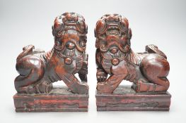 A pair of Japanese carved and red lacquered wood models of temple dogs, Edo period,21.5 cms high.