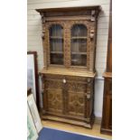 A late 19th century Flemish carved oak bookcase cupboard, width 102cm, depth 43cm, height 206cm