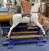 An early 20th century rocking horse on painted safety frame, (re-painted) width 126cm, height 114cm