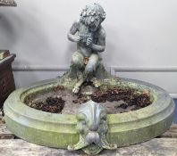 An early 20th century oval lead garden fountain formed as a seated satyr playing pan pipes with