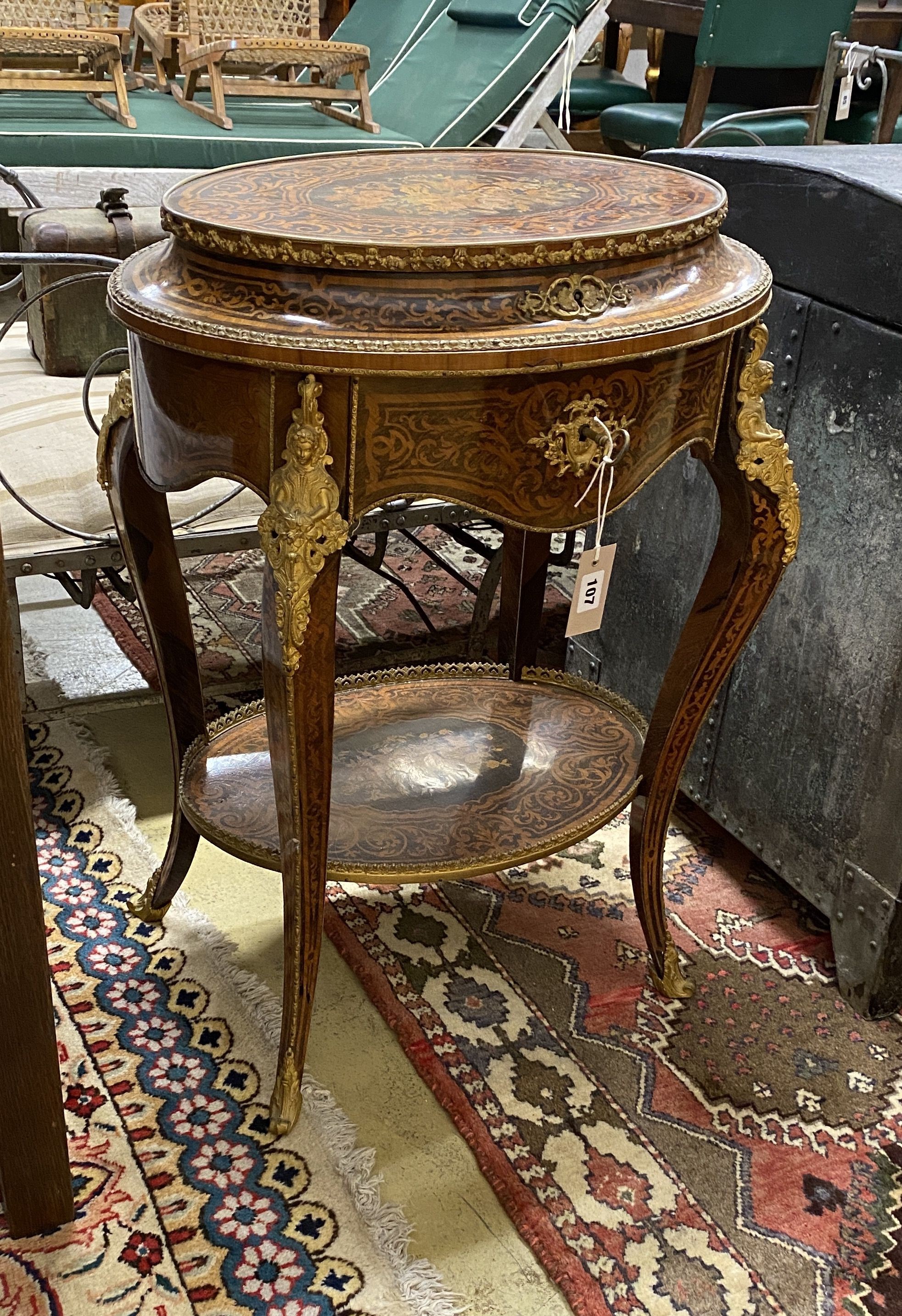 A Louis XVI style marquetry inlaid oval gilt metal mounted two tier work table, width 56cm, depth