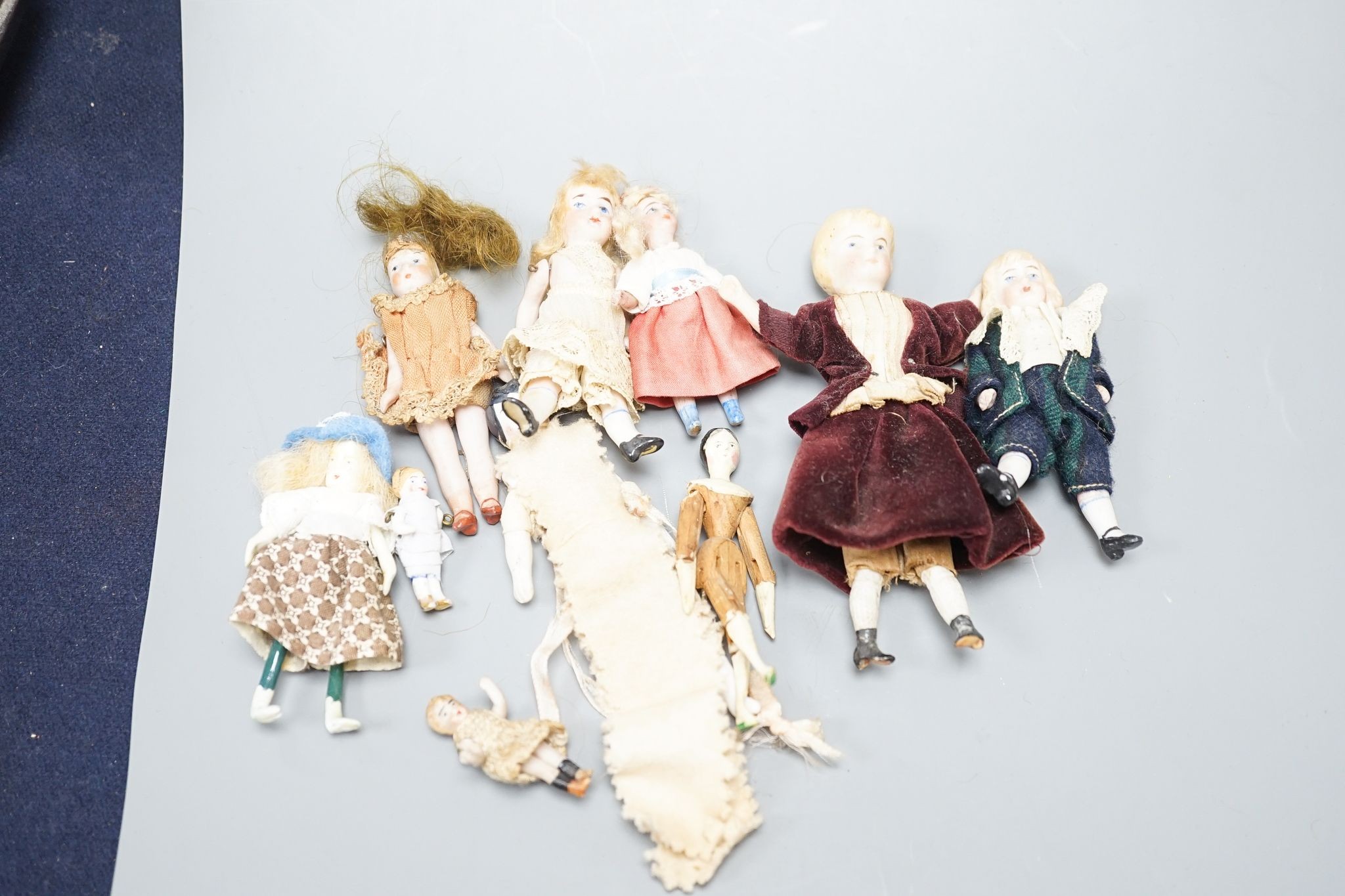 A collection of miniature bisque dolls and another larger doll in a wooden cradle, 11 dolls in - Image 4 of 8