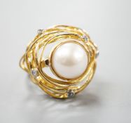 A modern 750 yellow metal, mabe pearl and diamond chip set modernist dress ring, size Q, gross 13.