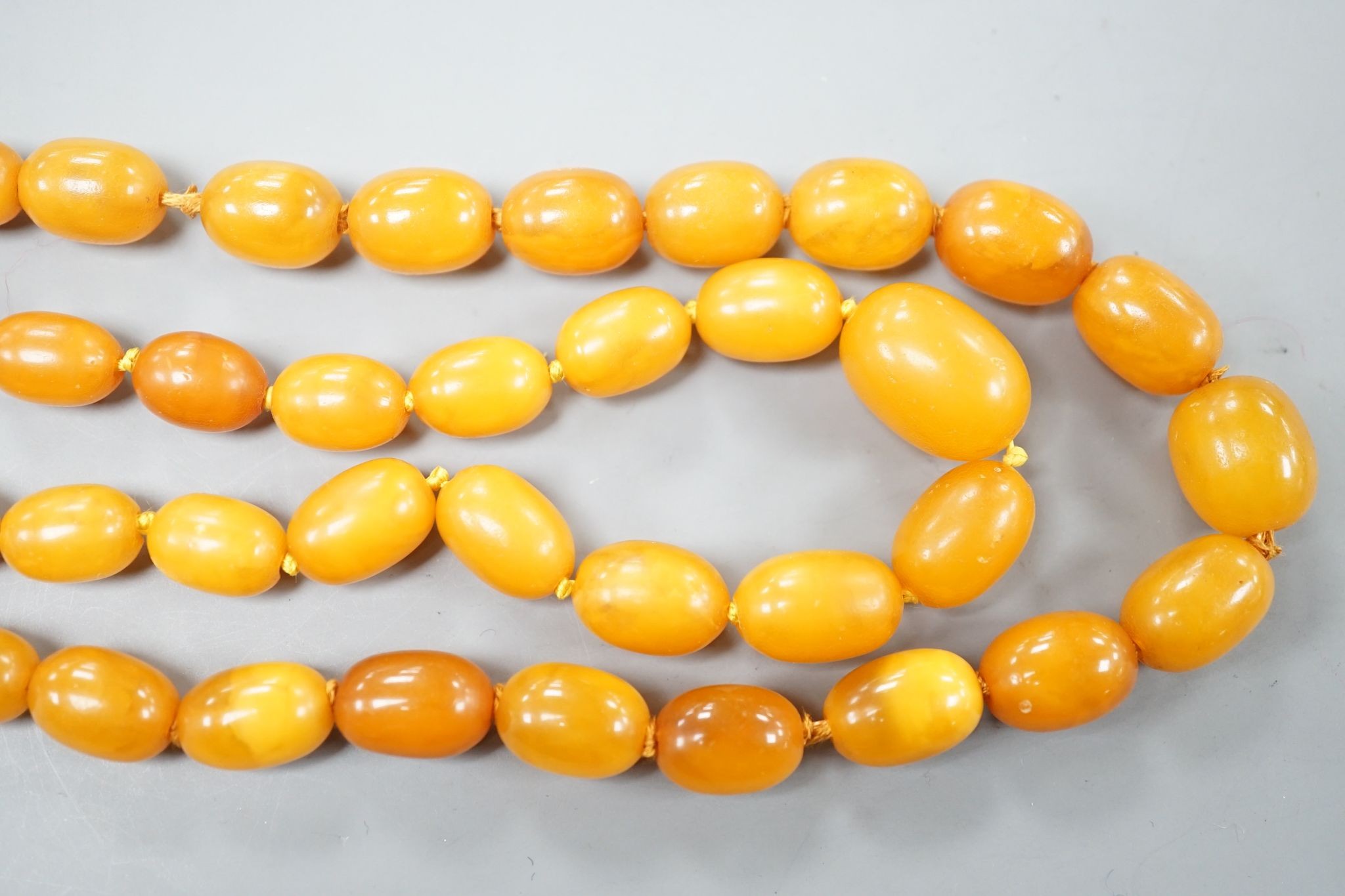 Two single strand graduated oval amber bead necklace, longest 70cm, gross weight 72 grams. - Image 5 of 5
