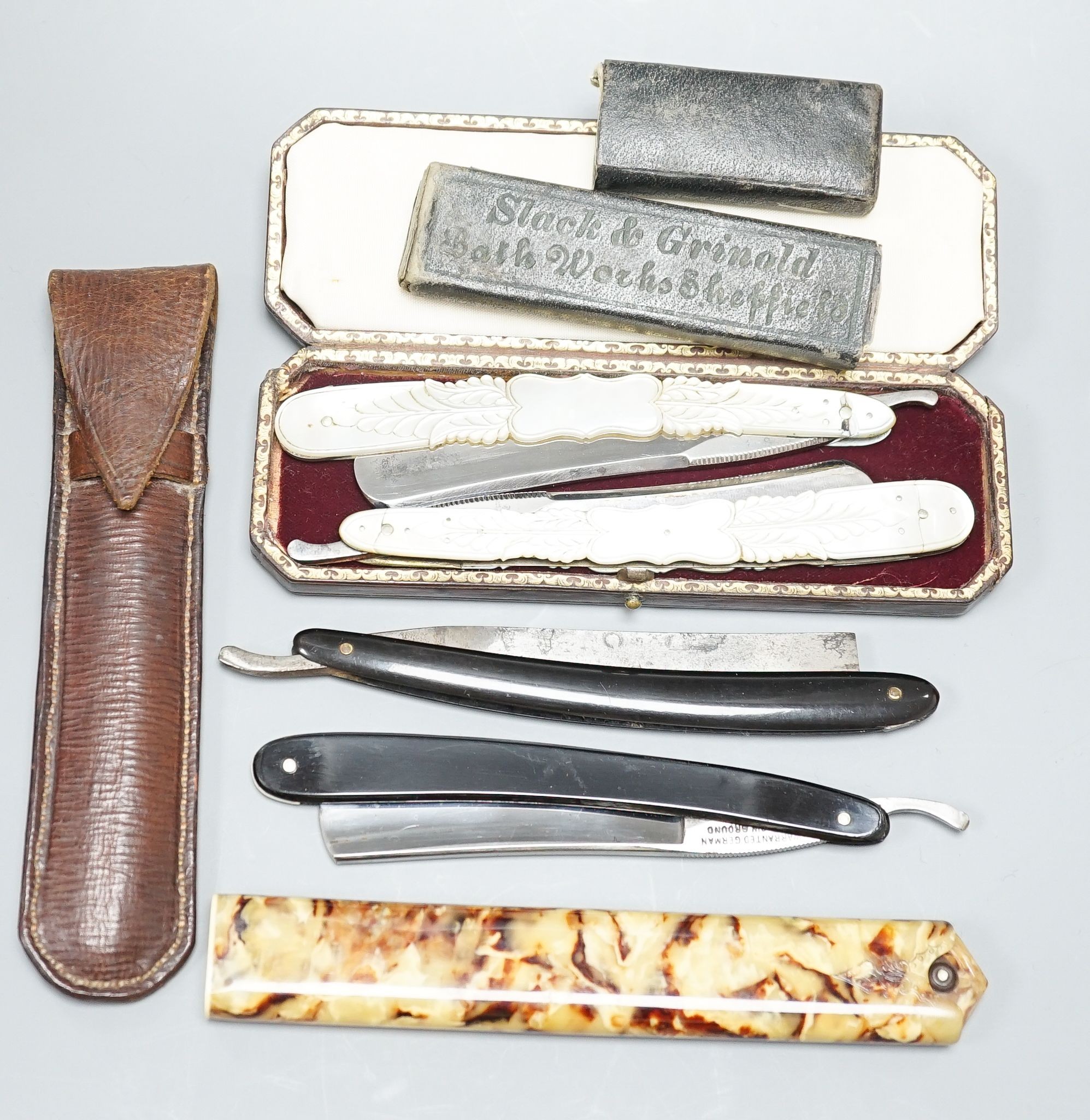 A leather cased pair of mother-of-pearl handled cut throat razors, by J Crawford and three other