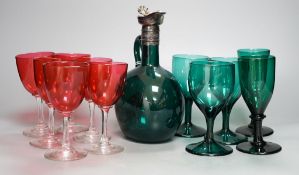 A Victorian dark green glass hock jug, five dark green wine glasses and 6 cranberry bowled wine