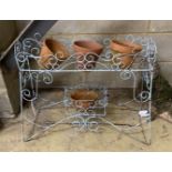 A painted wirework pot stand, width 68cm, together with four terracotta pots,