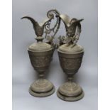 A pair of bronzed metal classical pedestal urns with scroll decoration and satyr masks (one handle