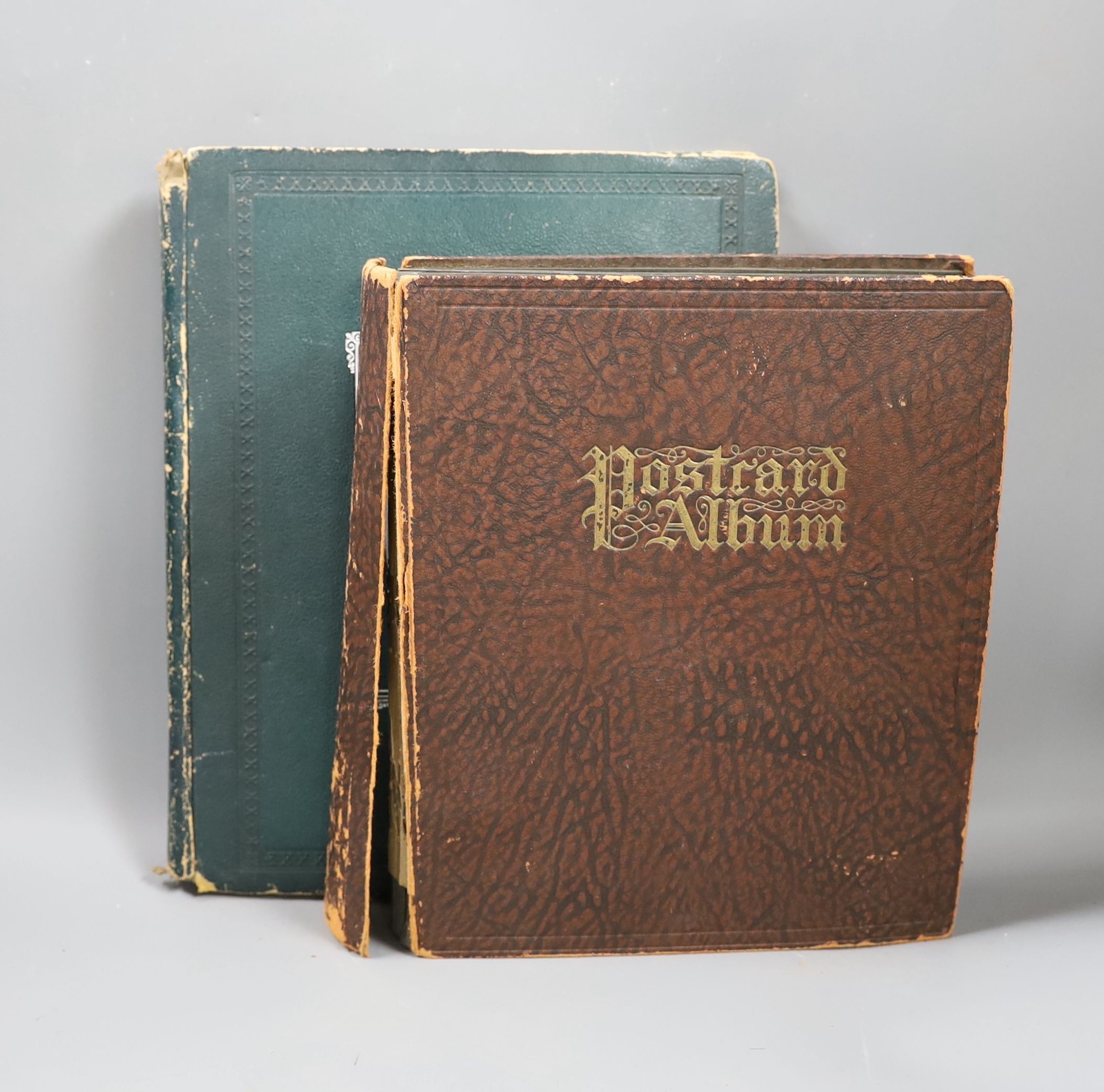 An Edwardian green postcard album, mounted with 68 risque cards and a brown album mounted with
