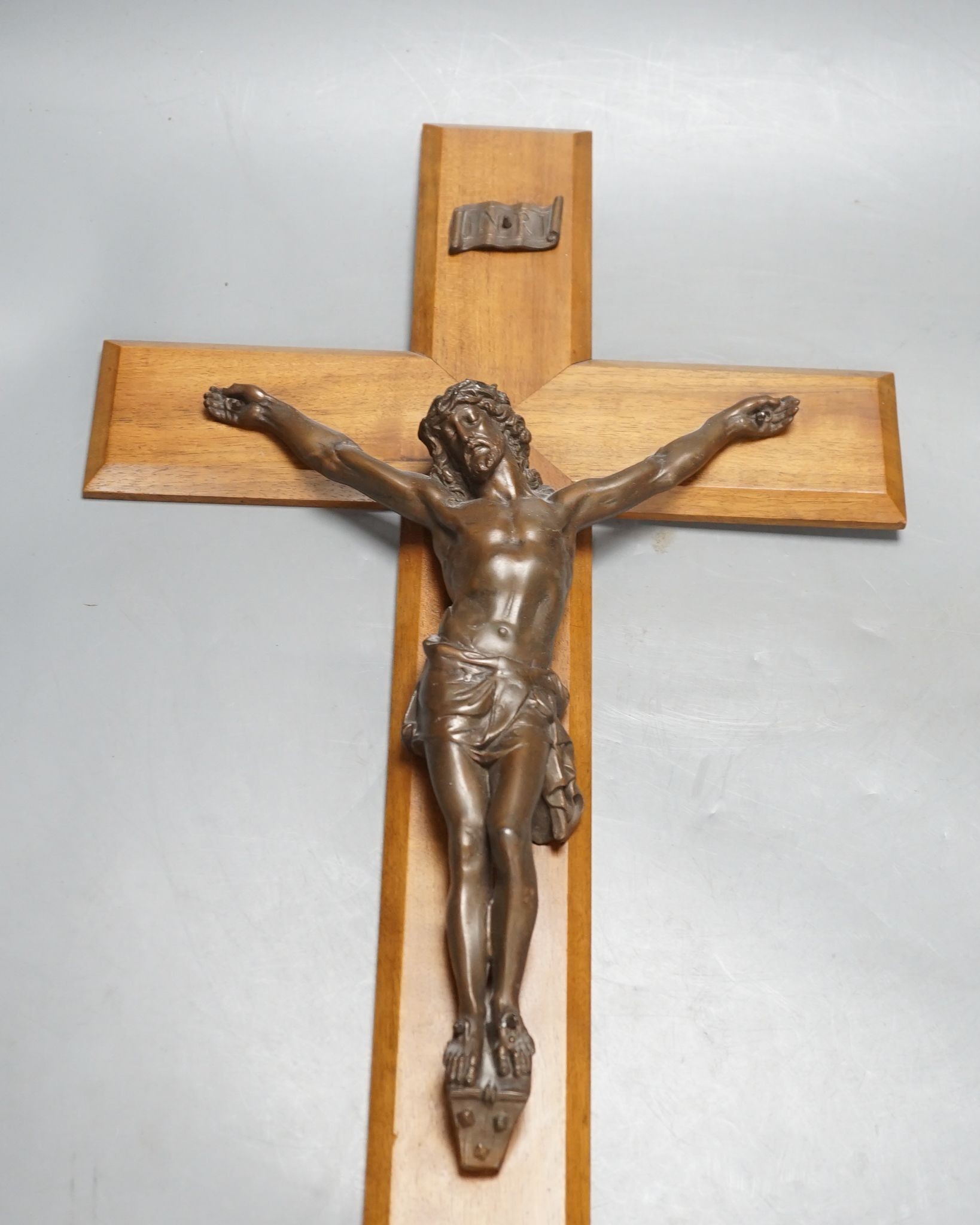 A bronze crucifix, mounted on a wooden cross,Height of cross, 60.5 cms.