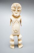 A Lega full-figured anthropomorphic sculpture of the short arm type, almond-shaped eyes. the