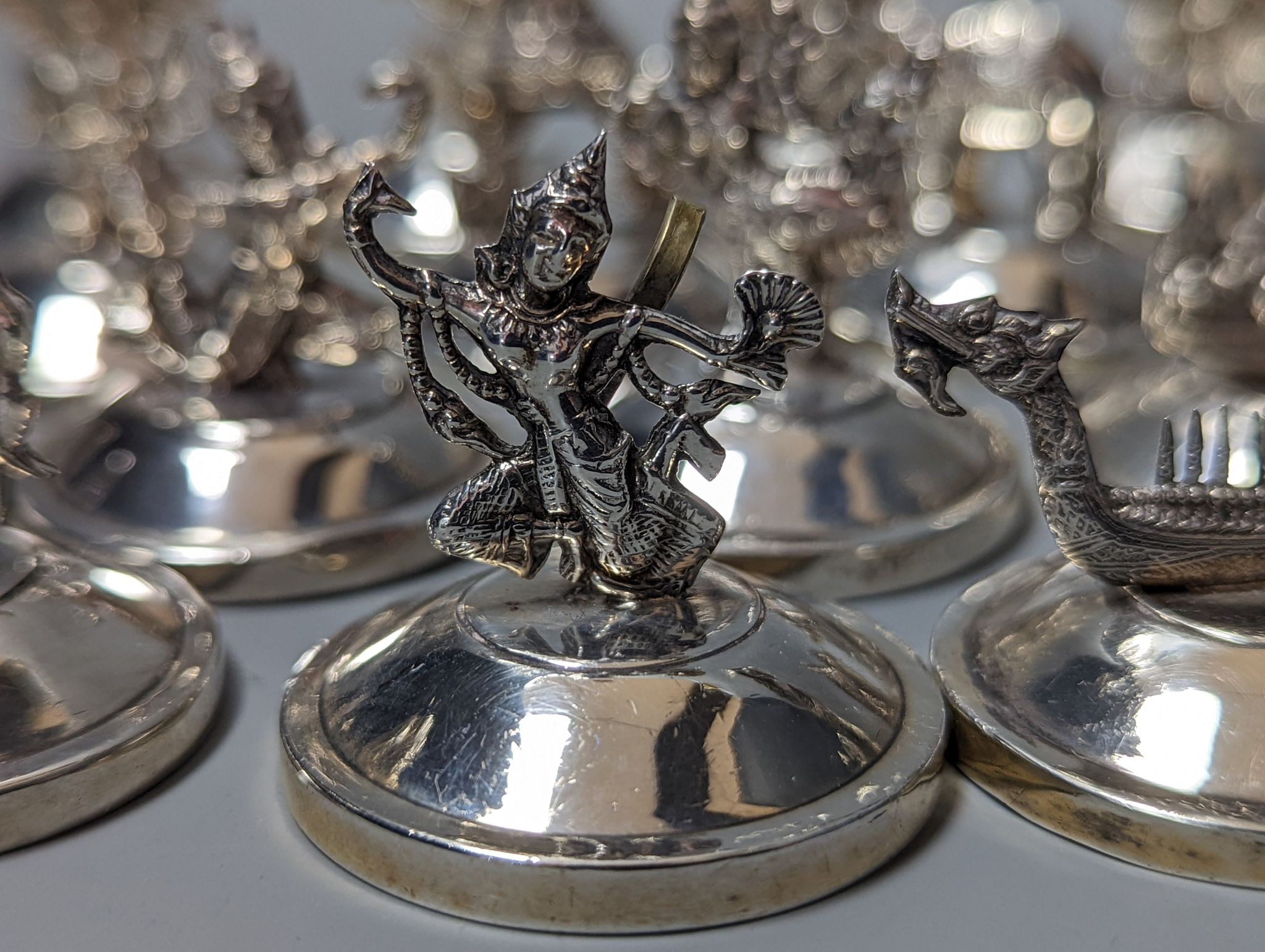 Sixteen assorted Siamese sterling mounted menu holders, modelled with figures, elephant, etc. - Image 3 of 17