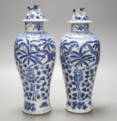 A pair of Chinese blue and white dragon vases and covers, circa 1900. 28cm