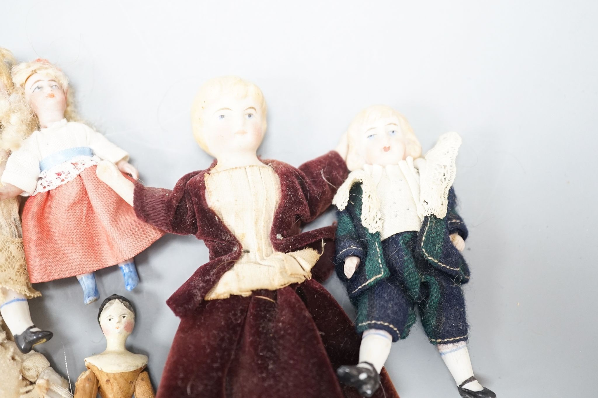A collection of miniature bisque dolls and another larger doll in a wooden cradle, 11 dolls in - Image 5 of 8