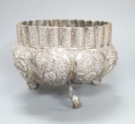 An Indian embossed white metal bowl, on three dolphin feet, diameter 13cm, 10oz.