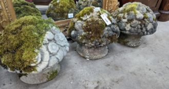 A set of three weathered reconstituted stone garden ornaments modelled as floral bunches, diameter