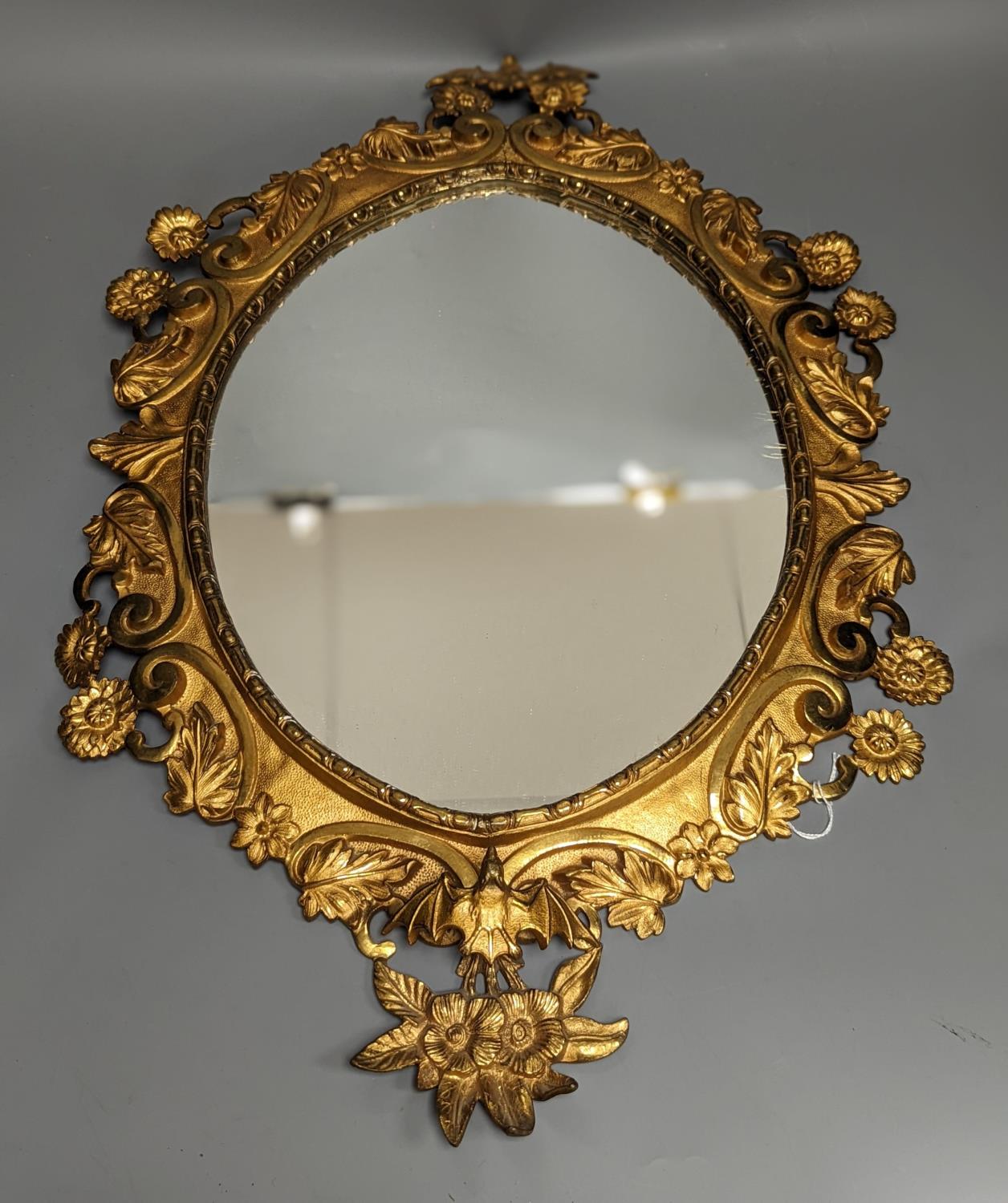A pair of gilt brass wall mirrors, decorated with bats and flowers 56cm