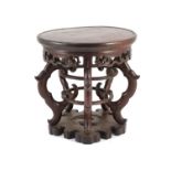 A Chinese hardwood stand, 19th century,the circular dish top above a fretted frieze, on four