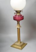 A Victorian brass and cranberry glass oil lamp,78 cms high.