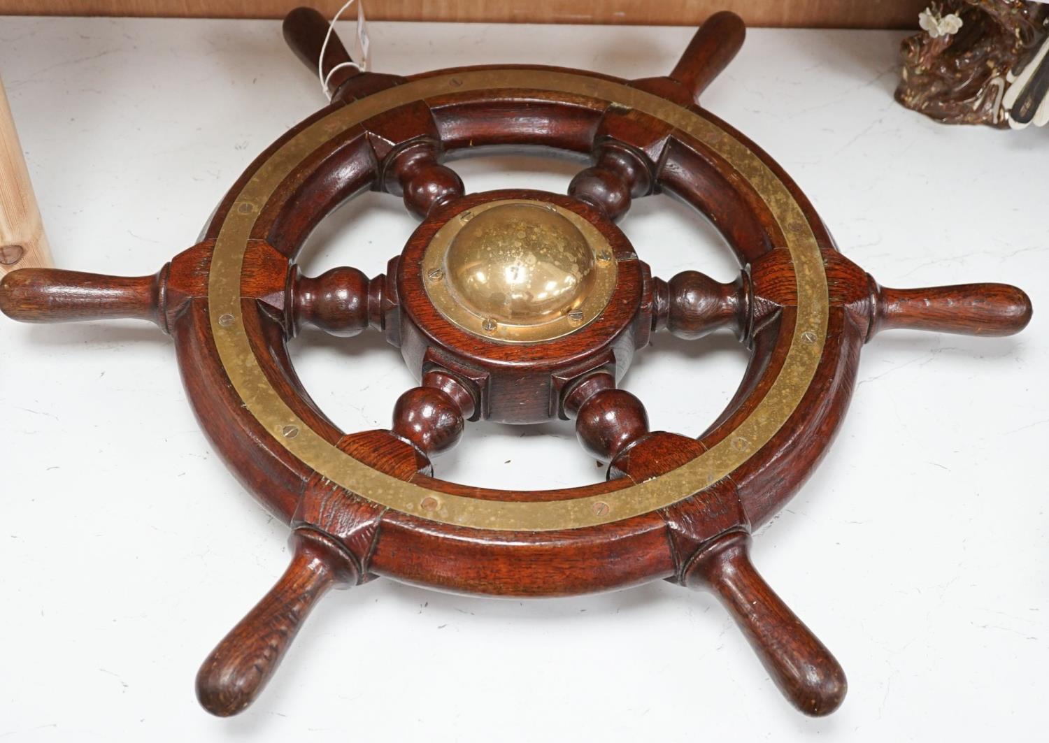 An early 20th century teak and brass mounted ship’s wheel 64cm