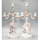 A pair of late 19th century German floral encrusted, figurative porcelain candelabra, 52 cms high.