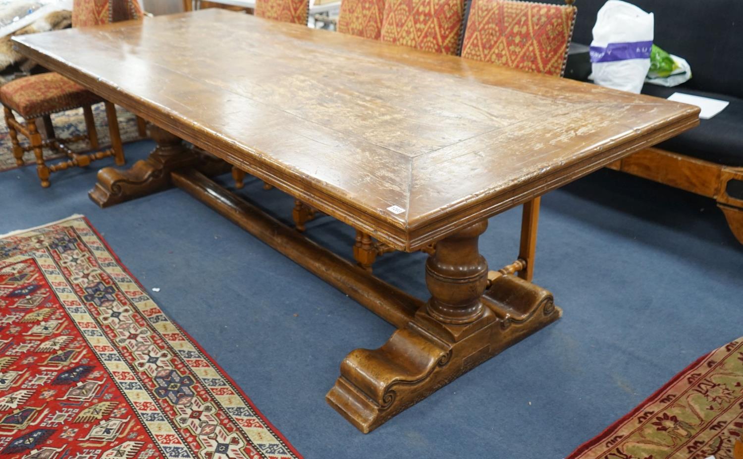 An 18th century style rectangular walnut refectory dining table on baluster end supports with