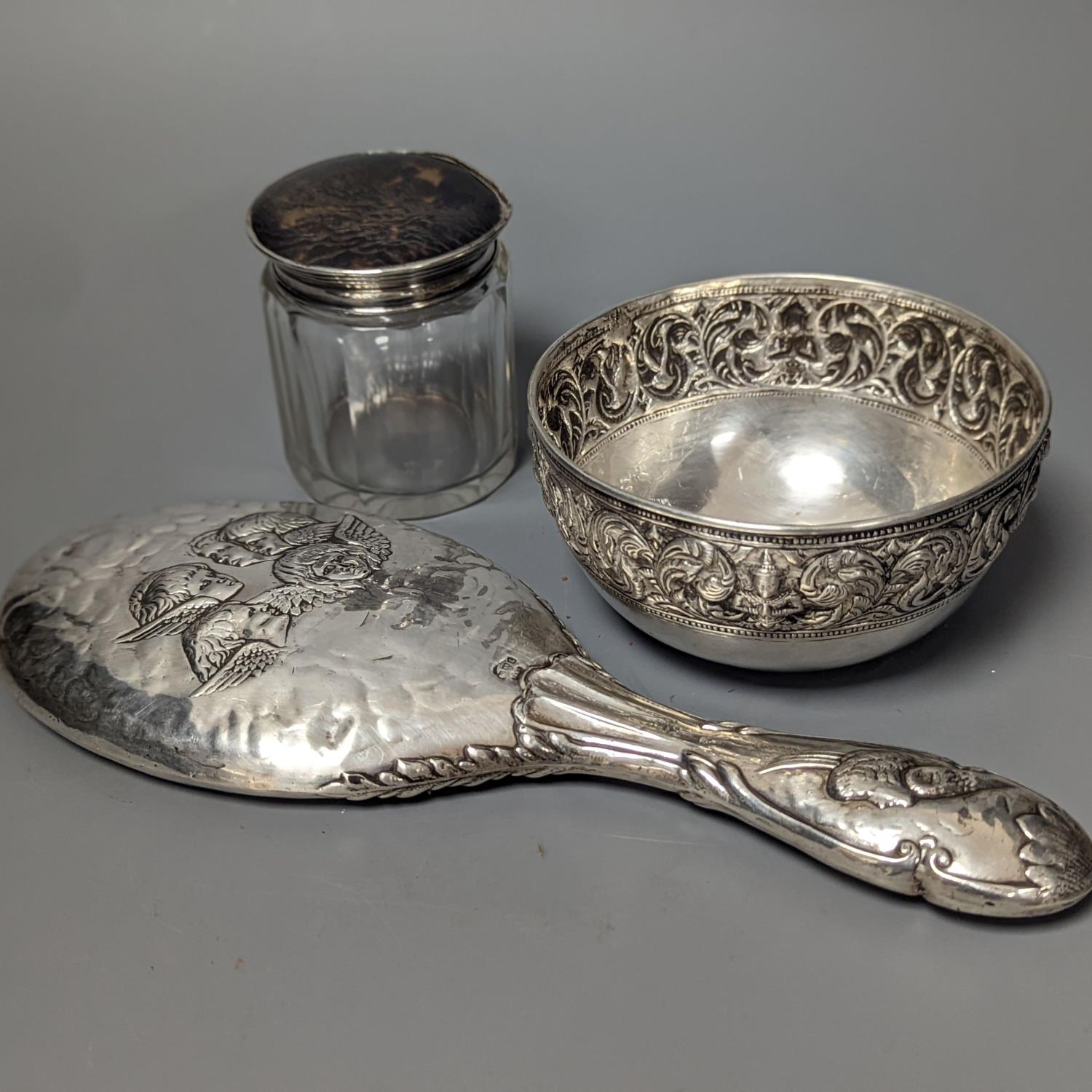 An Edwardian silver mounted 'Reynold's Angels' hand mirror, a silver and tortoiseshell lidded