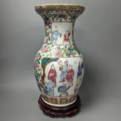 A 19th century Chinese famille rose vase on wooden stand,37 cms high including stand.