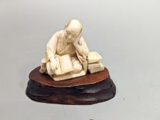 A Japanese ivory okimono of a scholar, Meiji period, signed,5 cms high not including stand.