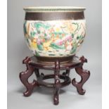 A Chinese famille rose ‘warriors’ jardiniere, late 19th century, wooden stand, 42 cms high including