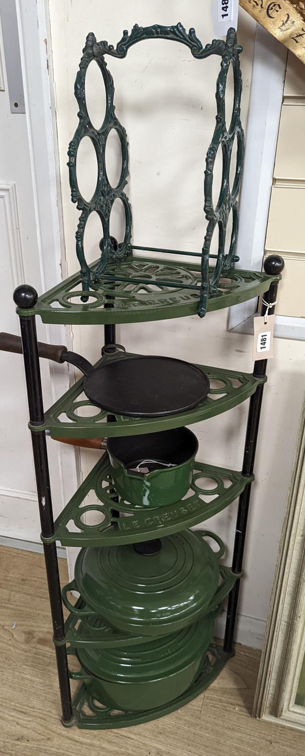 A green enamel Le Cruset pot stand, three pans and a bottle rack,stand 90 cms high.