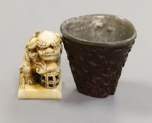 A Chinese or Japanese ivory lion dog 18th/19th century and a Chinese carved nut cup, 19th century.