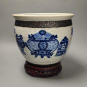 A Chinese blue and white crackle glazed jardiniere, early 20th century, wood stand. Total height