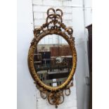 A late Victorian giltwood and gesso oval framed wall mirror, width 54cm, height 100cm