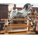 A vintage Ayres type dapple grey carved wood rocking horse on beech safety frame, length 130cm,