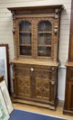 A late 19th century Flemish carved oak bookcase cupboard, width 102cm, depth 43cm, height 206cm