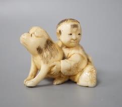 A Japanese ivory netsuke of a boy and puppy, Meiji period, unsigned, 4cm