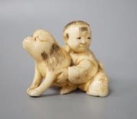 A Japanese ivory netsuke of a boy and puppy, Meiji period, unsigned, 4cm