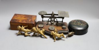 A set of three 19th century cast bronze cherubs, a set of lacquer coasters, a postal scale and a yew