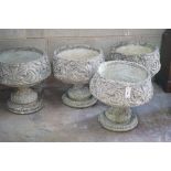 A matched set of four circular reconstituted stone garden planters, moulded with acanthus scrolls,