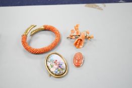 A yellow metal mounted carved coral oval brooch, 30mm, a mounted coral open bangle, a coral brooch