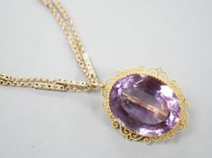 A yellow metal mounted oval cut amethyst pendant brooch, 34mm, gross 13.2 grams, on a Victorian