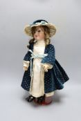 A Simon & Halbig doll, cream satin dress and blue velvet coat, open mouth, 44.5 cms high.