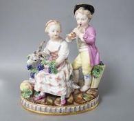 A 19th century Meissen figure group of a boy with a pipe, a girl with a grape and a goat, crossed