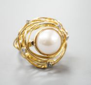 A modern 750 yellow metal, mabe pearl and diamond chip set modernist dress ring, size Q, gross 13.