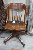 An early 20th century American walnut swivel desk chair by the Marble and Shattuck Chair Company,