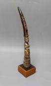 An African carved ivory divination tapper, probably Yoruba tribe on stand,35 cms high.