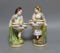 A pair of Victorian Minton's bone china figures holding baskets,20cms high.