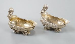 A pair of late 19th/early 20th century Hanau white metal salts, modelled as boat's with wheels and